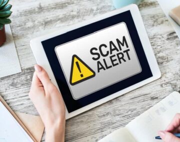 scam-alert-being-read-on-a-tablet-held-by-a-woman